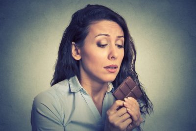 woman tired of diet restrictions craving sweets chocolate