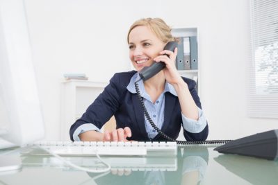 Young female executive using phone at office