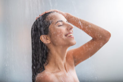 Positive woman taking hot shower
